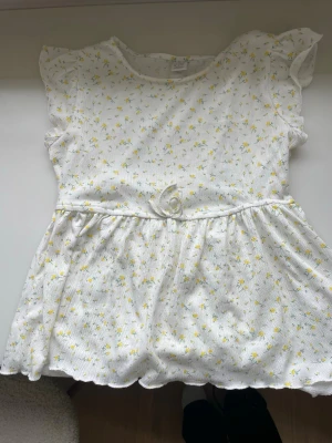 Blus/t-shirt med en rosett! - Blommig blus/t-shirt med en liten rosett från Lindex!!