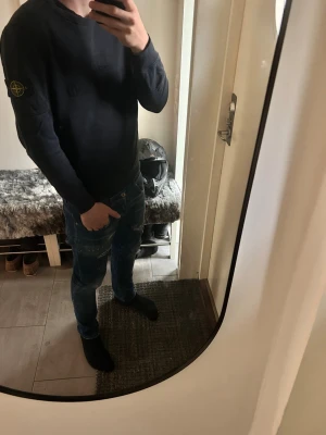 Svart tröja från Stone Island - Snygg svart sweatshirt från Stone Island med broderad logga på bröstet och ikonisk patch på ärmen. Tröjan har rund halsringning, ribbade muddar och är tillverkad i mjukt bomullsmaterial.