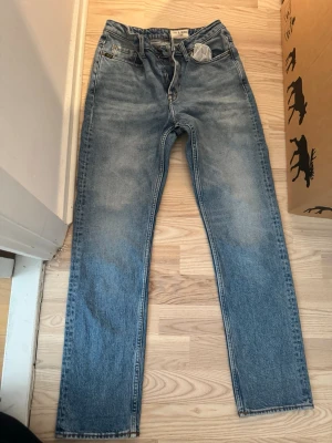 Blå raka jeans Tiger of Sweden - Snygga blå jeans från Tiger of Sweden med rak passform och klassisk femficksdesign. Jeansen har en ljus tvätt och är tillverkade i slitstark denim. Perfekta för en avslappnad och trendig look.