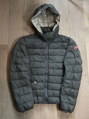 Colmar Jacka - Snygg och stilren Colmar jacka i storlek M. Mörk/svartgrön färg med Colmar-logga på ärmen och huva, perfekt inför hösten / vintern som är på ingång. Jackan är varm och passar perfekt till höst och vinter. Vid frågor hör av er! 