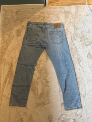 Ljusblå 502 Levis  - Säljer ett par klassiska ljusblå jeans med taperd  passform och fem fickor. Jeansen har en enkel design med normal midja och synliga sömmar. Perfekta för en avslappnad stil och passar till det mesta i garderoben. W36 L32
