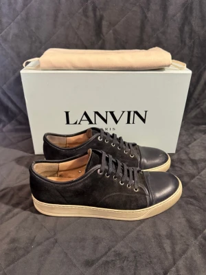 Lanvin - Vi säljer ett par eftertraktade, mörkblå lanvins captoe i storlek uk8 vilket motsvarar storleken 42. Skorna passar även storlek 43! Skorna är självklart äkta! Skorna är i mycket bra skick 9/10, de har endast en tydligare defekt på insidan, detta är en vanlig defekt på den specifika lanvin modellen! Skorna har inga andra tydliga defekter och behöver i princip endast rengöras lite, så är de som nya! Därav har vi satt priset på 1899kr! Kom gärna med frågor, box o dustbag ingår ej