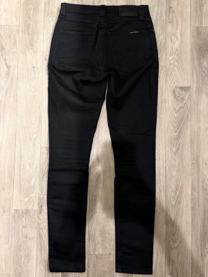 Nudie Jeans Svarta W29/L32 - Skinny Fit - Nudie Pipe Led svarta jeans med skinny fit passform som sitter tight och bekvämt och funkar till allt, storlek W29/L32, midja 36 cm, ytterbenslängd 106,5 cm, benöppning 14,5 cm, modellen är 185cm & väger 65kg, i fint skick.