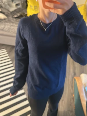Mörkblå stickad tröja från Lindex - Mysig mörkblå stickad tröja från Lindex med rund halsringning och ribbade muddar vid ärmslut och nederkant. Aldrig använd men har tyvärr inte kvar prislappen. Tror denna kostade 249 men inte söker! Jag tror denna skulle passa någon som har xs/s. Den är lite lång på mig som är 167 cm lång!