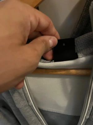 Grå hoodie med dragkedja från Hugo Boss - Snygg grå hoodie från Hugo Boss i storlek S. Hoodien har dragkedja framtill, huva och ribbade muddar. Tillverkad i mjukt material som känns skönt mot huden. Perfekt för en avslappnad och stilren look.