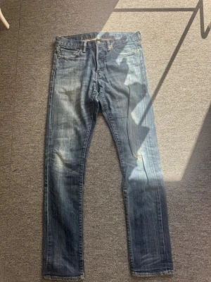 Ralph lauren Ljusblå raka jeans med slitningar - Säljer ett par Ralph lauren ljusblå jeans med raka ben och klassisk femficksmodell. Jeansen har slitningar och en liten reva på höger ben framtill. Materialet är denim i bomull och passformen är avslappnad. Perfekta för en casual look. Storlek 30/32