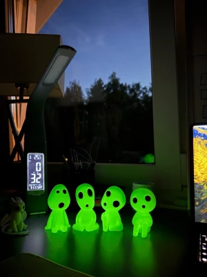 Glödande kodama-figurer 4-pack - Fyra små kodama-figurer i självlysande grön plast med svarta ögon och mun. Figurerna har olika sittande och stående positioner och är inspirerade av Studio Ghiblis filmer. Perfekt som dekoration på skrivbord eller hylla.
