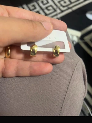 Guldpläterade chunky hoops - Säljer ett par chunky hoops i guldpläterad metall. Örhängena har en stilren, rundad form och ger en trendig look. Perfekta för dig som gillar minimalistiska men ändå iögonfallande accessoarer.