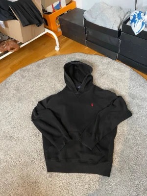 Svart hoodie från Polo Ralph Lauren - Snygg svart hoodie från Polo Ralph Lauren i storlek 18-20. Riktigt bra skick, pris kan diskuteras vid snabbaffär.