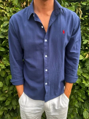 Ralphlauren - Linneskjorta S - Säljer en riktigt snygg linneskjorta från Ralph Lauren i mycket fint skick. Den är endast använd ett fåtal gånger och har därför inga tecken på användning. Skjortan är tillverkad i ett tunt och luftigt linnematerial som passar perfekt under varmare dagar. Storleken är S, men den passar även dig som vanligtvis använder XS beroende på önskad passform.  Hör gärna av dig om du har några frågor eller vill se fler bilder!