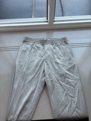 Beige mjukisbyxor från Filippa K - Säljer dessa snygga beiga kostym byxor från Filippa K i riktigt fint skick. Inte så dressade så kan användas till alla möjliga outfits och sammanhang. Passar mig som är 185 