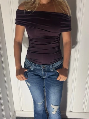 Off shoulder topp  - Trendig off shoulder topp med lappen kvar som inte säljs mer. Toppen har åtsittande passform, draperad effekt och korta ärmar💗. Tillverkad i ett stretchigt, mjukt material som sitter snyggt på kroppen🤩. Perfekt för dig som vill ha en stilren och modern look.