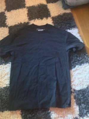 Svart t-shirt med tryck - Svart t-shirt med vit text på ryggen: 'She said "Keinemusik or me" Sometimes I miss her..'. Klassisk passform och rund halsringning. Perfekt för dig som gillar statement-plagg och enkel stil.