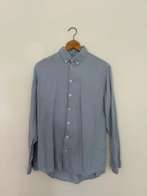 Selected Homme linneskjorta - Säljer en blå skjorta från Selected Homme i 100 % linne. Klassisk och stilren modell som passar perfekt till både vardag och sommarens finare tillfällen. Skjortan är i fint begagnat skick och väl omhändertagen.