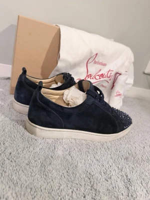 Christian Louboutin Navy blue (junior spikes  - Ett par fräscha Louboutins i mycket gott skick  Skorna är i storlek 41 men passar även 42  Skorna är sparsamt använda och är i ett gott skick  Köpta för 4999 men kan tänka mig att gå ner i pris🤝  Allt på bilden hänger med men skickas ej i orginal box pga att den är sönder.    Allt detta ingår  Sko påsar  Liten påse Sko snören (vit)