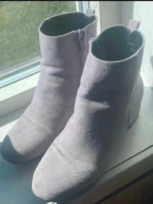 Ljuslila mocka stövletter - Snygga ljuslila stövletter i mockaimitation med rundad tå och låg klack. Dragkedja på sidan för enkel på- och avtagning samt diskreta sömdetaljer. Perfekta för dig som vill ha en stilren och trendig look.