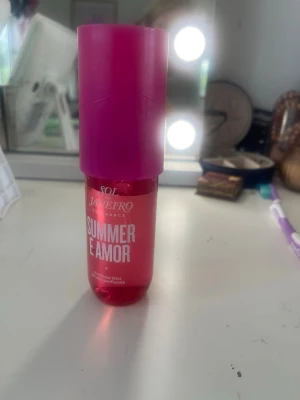 Sol de Janeiro Summer E Amor mist - Fräsch och färgstark body mist från Sol de Janeiro i doften Summer E Amor. Flaskan är cylinderformad i plast med en intensiv rosa färg och matchande lock. Perfekt för dig som gillar tropiska och somriga dofter.