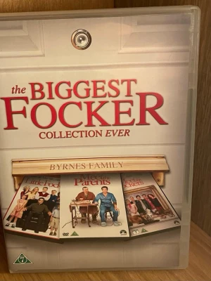 The Biggest Focker Collection Ever DVD-box - Samlarbox med filmerna Meet the Parents, Meet the Fockers och Little Fockers. Boxen är i plast med färgglada omslag och tydliga filmtitlar på framsidan. Perfekt för dig som gillar komedier och vill ha hela Focker-serien samlad. Perfekt Skick