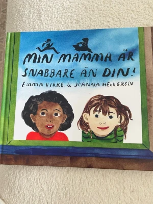 Min mamma är snabbare än din! - En färgglad bilderbok med hårda pärmar, illustrerad av Joanna Hellgren och skriven av Emma Virke. Omslaget visar två barn och boken har en lekfull, akvarellmålad stil. Utgiven av Lilla Piratförlaget. Perfekt för dig som gillar humoristiska och fantasifulla berättelser.
