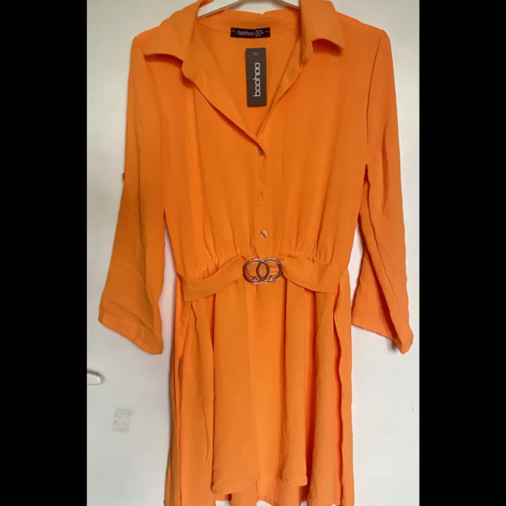 Från Boohoo Orange skjortklänning med bälte Säljer för att jag tyckte den var för kort, aldrig använd😇 Nypris var 450kr. Klänningar.