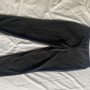 Kostymbyxor - Väl använda kostymbyxor. Storlek L. En söm är trasig på insidan av vänster ankel. Går bra att använda ändå, förmodligen lätt och laga för den händige.