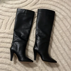 Stövlar - Stövlar med klack från H&M i läderimitation. Aldrig använda 