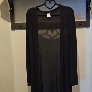 Kofta - En lång tunn kofta. Räcker mig till vaderna och jag är 164cm