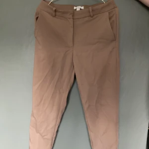 Kostymbyxor - Säljer dessa bruna kostymbyxor, endast testade. Byxorna är i ankellängd och i storlek 42. Köparen står för frakten.