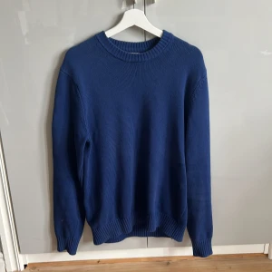 Blå stickad tröja, Mango, storlek M - Blå stickad tröja från Mango i storlek M. Materialet är 100% bomull. Har en liten fläck på sidan men inget som man lägger märke till.    