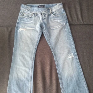 Armani jeans - Lågmidjade vintage Armani jeans med cool knäppning! Så snygga slitningar. En rosa fläck på baksidan men inget man tänker på. Midjemåttet rakt över : 40 cm Innerbenslängden : 80 cm En knapp saknas (bild 3)men jätte lätt att sy på och funkar annars ändå. 