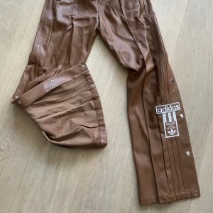 Adidas Originals Popper Pants - helt nya & oanvända coola adidas popper pants i brunt konstläder storlek XS!