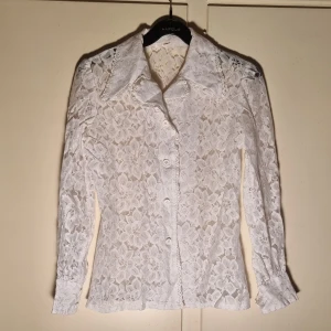 Spetsblus - Elegant och vacker spets blus med vita stora blommor.  Som ny! Tyvärr är lappen med tvättanvisning borta, hittar iaf ingen. Därav är också märke okänt.  Djur finns I hemmet. 