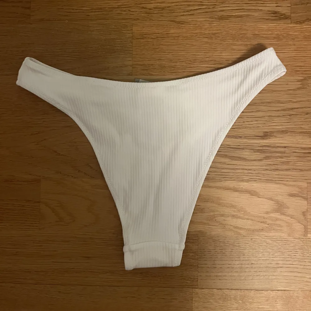Säljer denna vita bikiniunderdelen från H&M då den är för stor för mig! Prislappen och skyddet sitter kvar och den är endast testad en gång med dubbelt skydd så i princip oanvänd!. Shorts.
