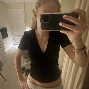 Topp - T shirt med en liten detalj i mitten. Använd 1 gång, säljer pga kommer inte till användning. Super skön.