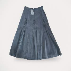 Kjol från Nygårdsanna, modell Long Skirt. Helt ny, med prislapp kvar. Snygg kjol med lagda veck fram. Dragkedja i sidan. Fodrad. Längd 99 cm.  Storlek: 40 Material: 67 % bomull, 33%siden