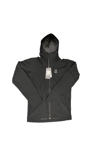 Finch Proof Jacket Men - Oanvänd Haglöfs jacka. Här är en mångsidig regnjacka som är perfekt för vandring eller vardagsbruk utomhus. Vattentät och lätt. Ordinarie pris 2200 sek