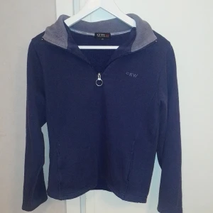 Mörkblå ridtröja från CRW XS - Mycket fin mörkblå ridtröja från märket CRW. Bra skick! XS. 80% bomull 20%polyester 