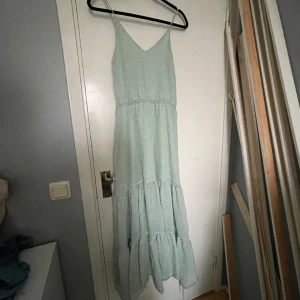 Lång mintgrön klänning - Lång klänning som funkar perfekt på sommaren eller för att ha som layering plagg. Från weekday i strl 34, men passar 36 också.