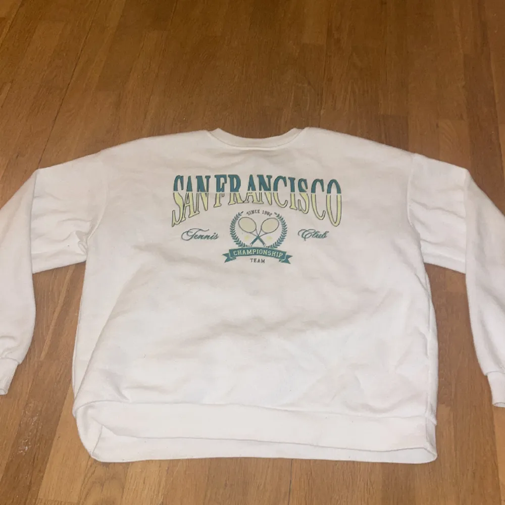 En vit tröja med grön text det står ”san francico” och tennis. Den är i bra skick ifrån primark i storlek 146/10-11 år:. Hoodies.