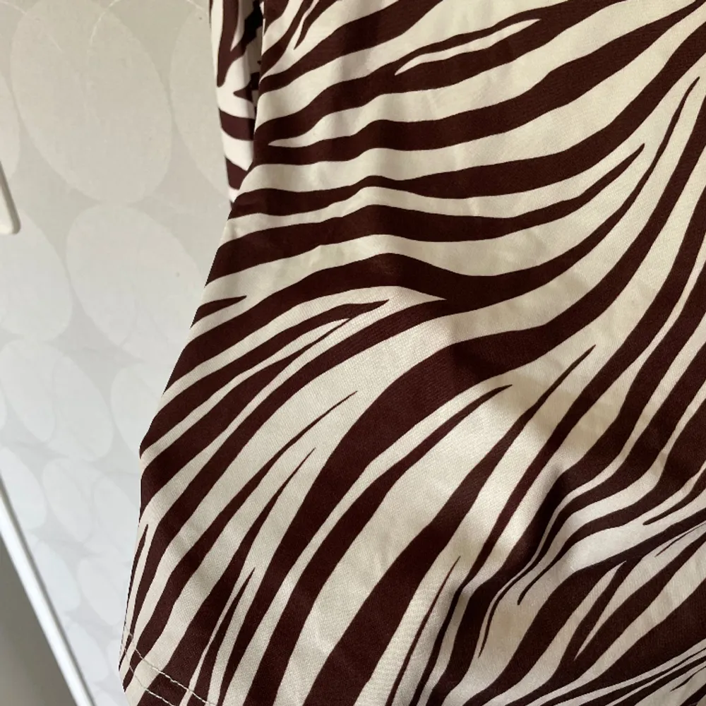 En tröja i zebramönster, färgerna brun och vit. Är väldigt skönt material, sitter tight. Fint skick!. Tröjor & Koftor.