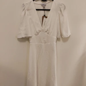 Vit klänning - Köpte klänningen förra året för min student som en backup. Den har prislapparna kvar och har aldrig använt. Skulle passa perfekt som studentklänning eller sommarklänning. Är en storlek S och har knytning i midjan vilket gör att det går att justera.
