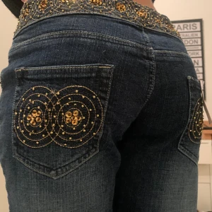Lowwaisted bootcut jeans med coola detaljer  - Jättesnygga lowwaisted bootcut jeans med coola detaljer på fickorna och baksidan. Helt nya, till och med lappen kvar. Säljer då dom är för stora!