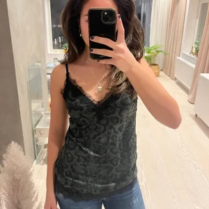 Rosemunde linne - Mörkgrönt linne med svart spets från Rosemunde. Ormmönster. Bra skick då knappt använd.