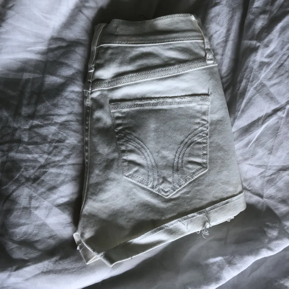 Högmidjade jeansshorts i vitt och lite slitningar från Hollister i storlek w24.. Shorts.