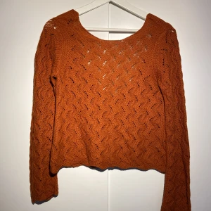 Stickad backless tröja - Mörkorange stickad tröja som är backless.