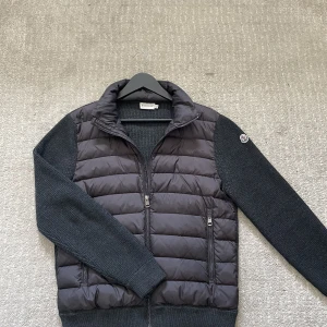 Moncler cardigan  - Säljer en Moncler cardigan som är i bra skick! Storlek M! Jackan har ett litet hål längst på ena ärmen! Hör gärna av dig om du har frågor!