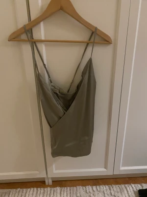 Linne - Festligt linne i silkesmaterial i en dämpad grön färg, perfekt för fest! Helt ny och oanvänd med prislappen kvar! Passar en 38/40.