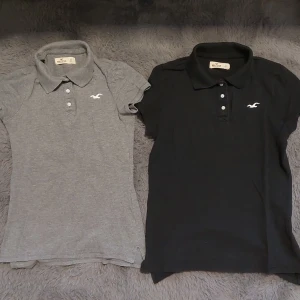 Slim knit hollister piké t-shirt - Två fina Piké t-shirts. Den gråa är i Xs och den svarta i S. Köpte de för ca 200 kr styck och säljer helst båda tillsammans för 100kr men om man gärna vill så kan man köpa 1 för 70kr. Dem är i väldigt bra skick, inga hål och inga fläckar.