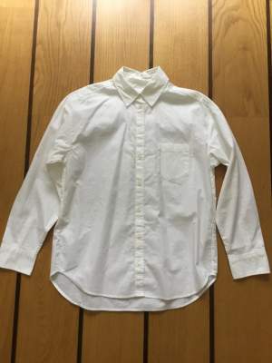 Vit lång skjorta från Monki i storlek XS. 100% bomull. Axelbredd: 49 cm, längd framstycke: 68 cm, längd bakstycke: 71 cm. 