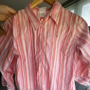 Lacoste Skjorta - En vintage lacoste-skjorta köpt på seconhand men aldrig använd. I kvinnoSTRLK 44 men sitter som en M man. 